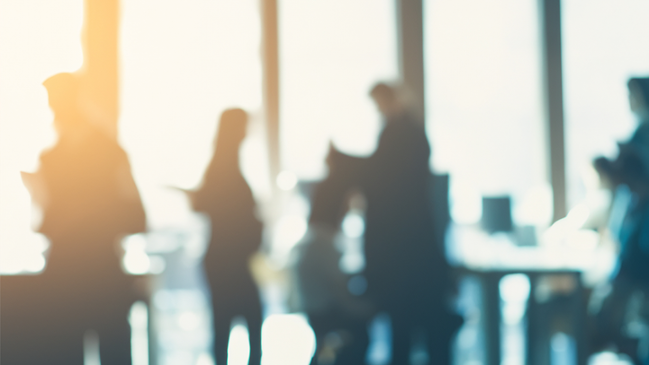 Das Bild zeigt ein Büro mit arbeitenden Menschen Das Bild zeigt ein Büro mit arbeitenden Menschen