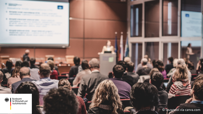 Auf dem Bild zu sehen ist, wie eine Person vor mehreren Leuten bei einer Veranstaltung einen Vortag hält. Auf dem Bild zu sehen ist, wie eine Person vor mehreren Leuten bei einer Veranstaltung einen Vortag hält.