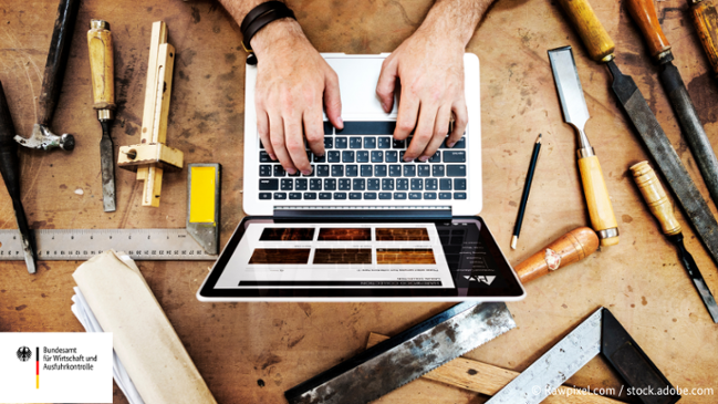 Auf dem Bild ist ein Mann zu sehen der in einer Werkstatt an seinem Laptop arbeitet. Auf dem Tisch liegen überall um den Laptop Wekzeuge herum. Auf dem Bild ist ein Mann zu sehen der in einer Werkstatt an seinem Laptop arbeitet. Auf dem Tisch liegen überall um den Laptop Wekzeuge herum.