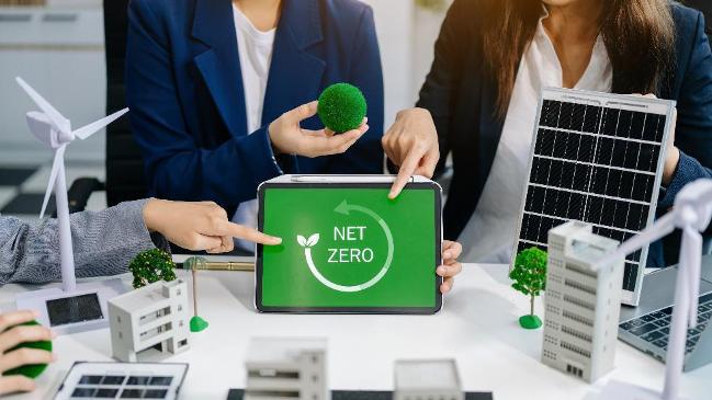 Mitarbeiter des Geschäftsteams planen. Hände zeigen auf den Laptop mit einem grünen Logo.  Mitarbeiter des Geschäftsteams planen. Hände zeigen auf den Laptop mit einem grünen Logo.