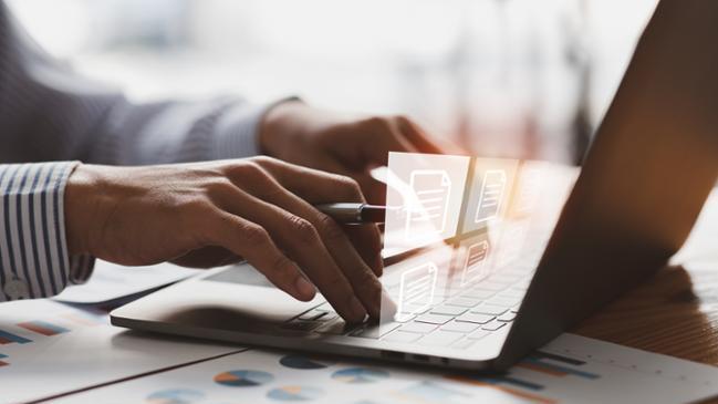 Geschäftsmann, der an einem Laptop-Computer arbeitet und Dokumente elektronisch hochlädt. Geschäftsmann, der an einem Laptop-Computer arbeitet und Dokumente elektronisch hochlädt.