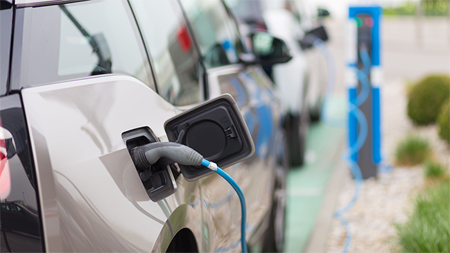 Elektrofahrzeug tankt Strom an einer Ladesäule Elektrofahrzeug tankt Strom an einer Ladesäule