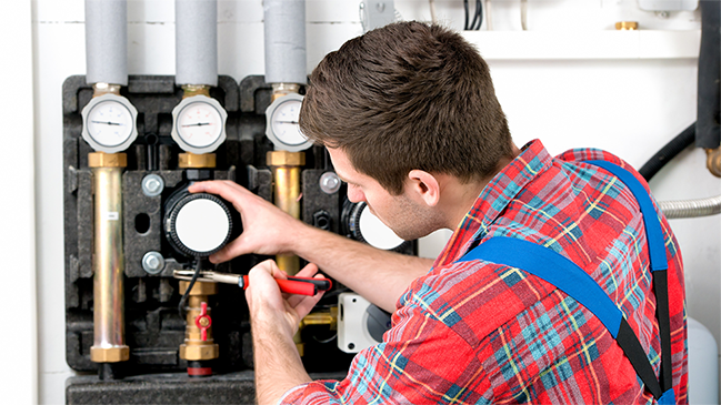 Handwerker arbeitet an der Heizungsanlage Handwerker arbeitet an der Heizungsanlage