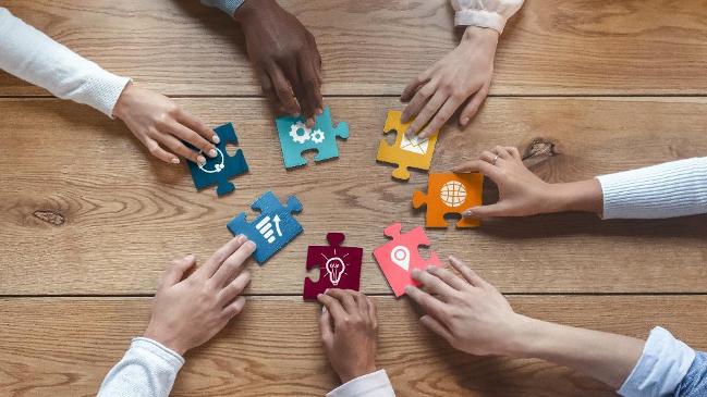 Hände die nach Puzzelstücken grifen Hände die nach Puzzelstücken grifen