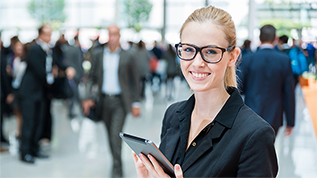 verweist auf: Messeprogramm Young Innovators 2025 Frau mit einem Tablet in der Hand (verweist auf: Messeprogramm Young Innovators 2025)